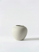 Minimalist white ceramic vase on a white background