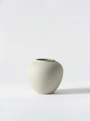 Minimalist white ceramic vase on a white background