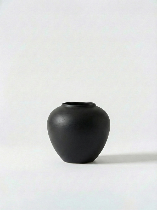 Minimalist black ceramic vase on a white background