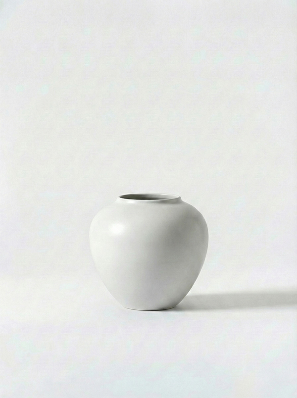 Minimalist gloss white ceramic vase on a white background