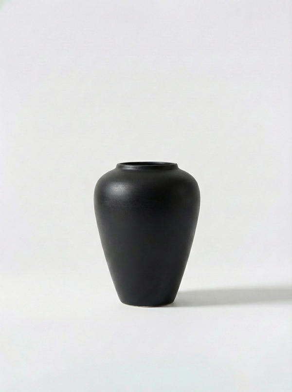 Minimalist black ceramic vase on a white background