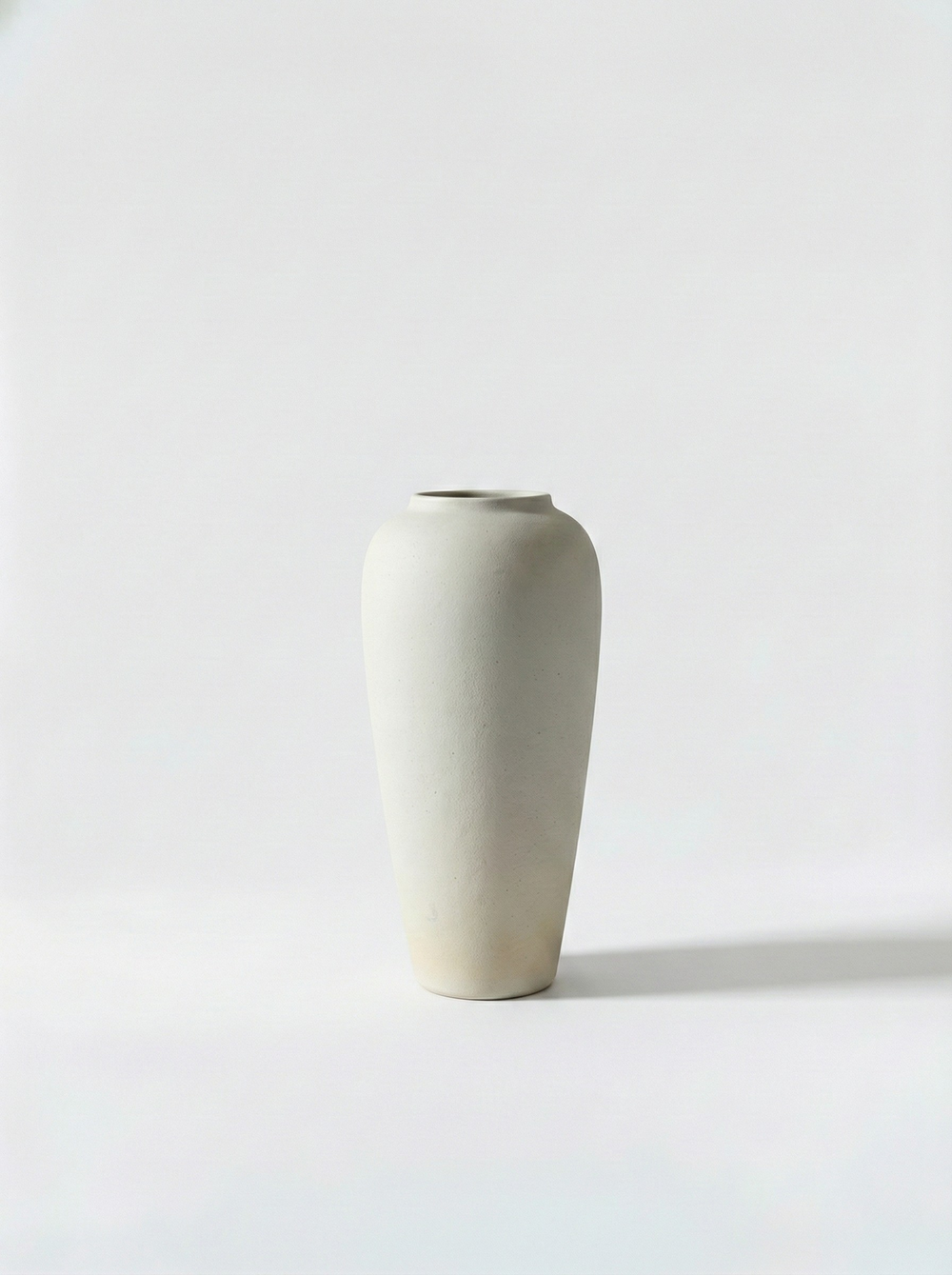 Minimalist white ceramic vase on a light grey background