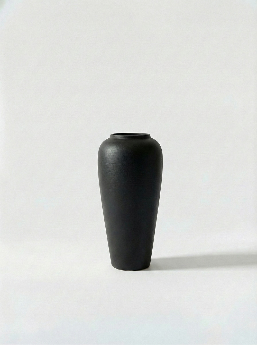 Minimalist white ceramic vase on a light grey background
