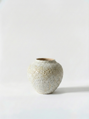 Textured ceramic vase on a light gray background