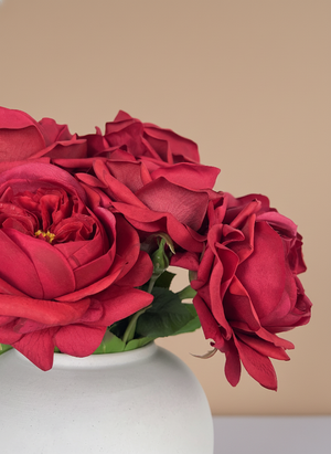 Lifelike faux red rose blooms with layered petals styled in a minimalist ceramic vase #red