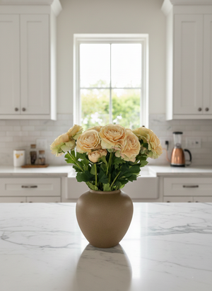 Peach faux ranunculus arrangement in a matte white ceramic vase styled on a bright modern kitchen bench top #soft-peach 