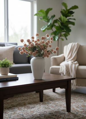 Pink real touch faux pompom flowers styled in a matte ceramic vase on a modern coffee table in a living space #light-pink