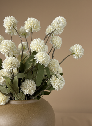 Close up of white real touch faux pompom flowers with delicate textured blooms arranged in a ceramic vase #white
