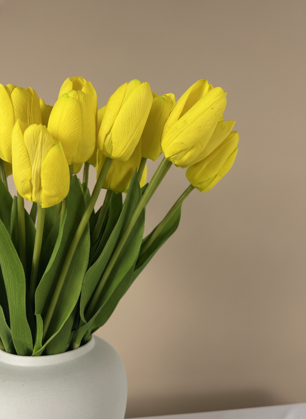 Close up of yellow faux tulips with realistic petal texture and natural green leaves in a minimalist vase #yellow