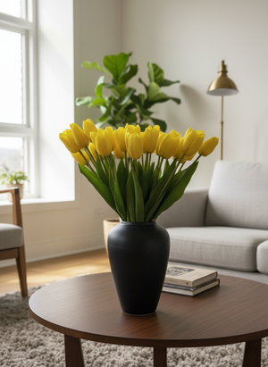 Premium yellow tulips in a black vase on a wood coffee table in a bright, modern living room. #yellow