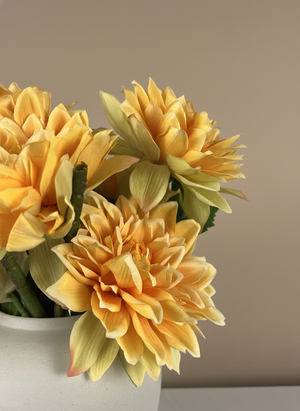Detailed close-up of artificial apricot orange dahlia blooms with layered petals in a ceramic vase #apricot-orange