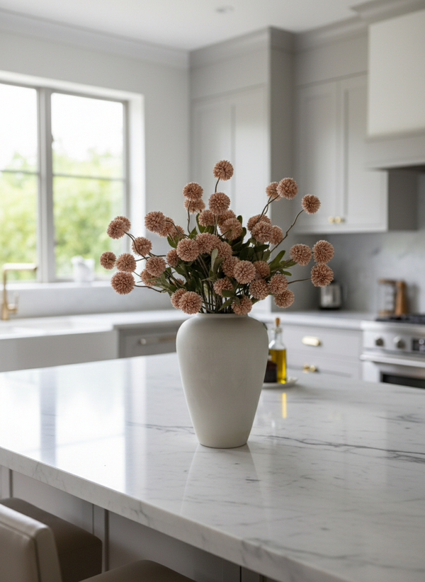 Pink coloured real touch faux pompom flowers styled in a matte ceramic vase on a marble kitchen island #light-pink
