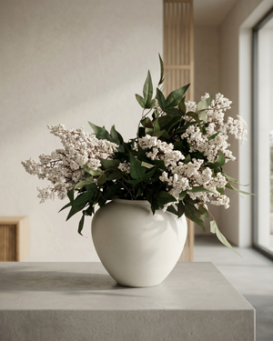 Real touch white faux berry arrangement with green foliage on light-coloured surface #white