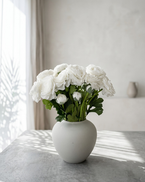 Realistic real touch white faux ranunculus arrangement in a matte ceramic vase styled on a concrete surface #white 