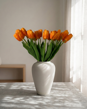 Real touch apricot orange faux tulips in a matte off white ceramic vase styled on a marble table for modern home decor #apricot-orange