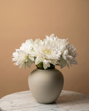Real touch white faux dahlia arrangement in a matte ceramic vase on a round marble table #white