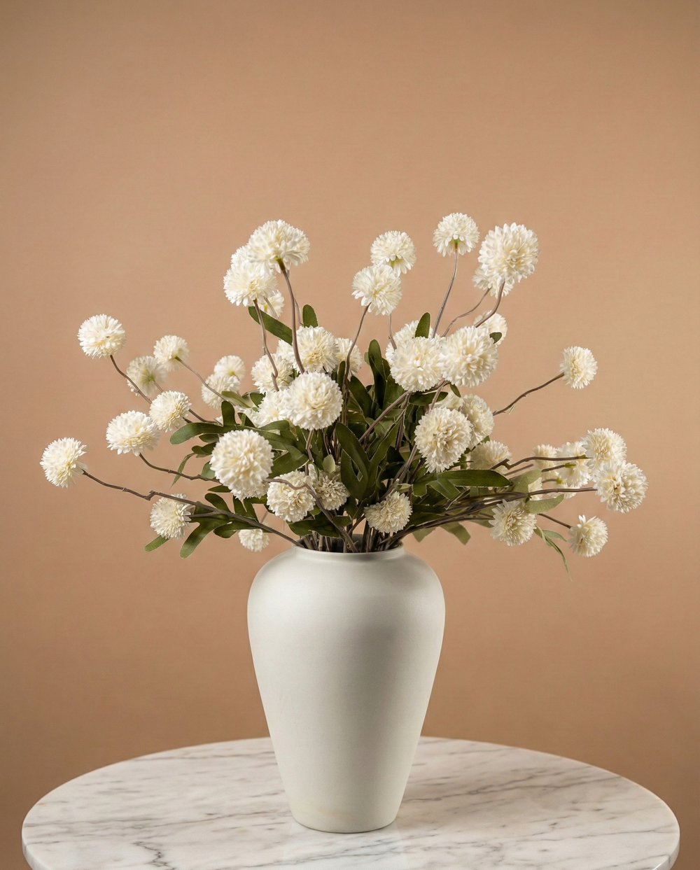 White vase with whitereal touch faux pompon  flowers on a light wooden surface #white