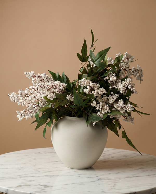 Real touch white faux berry arrangement with green foliage in a minimalist ceramic vase on a marble table #white