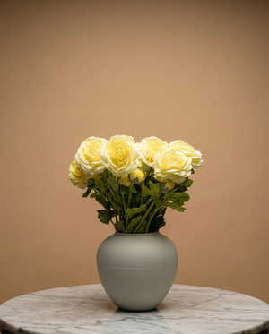 Realistic real touch yellow faux ranunculus arrangement in a matte ceramic vase styled on a marble table #yellow