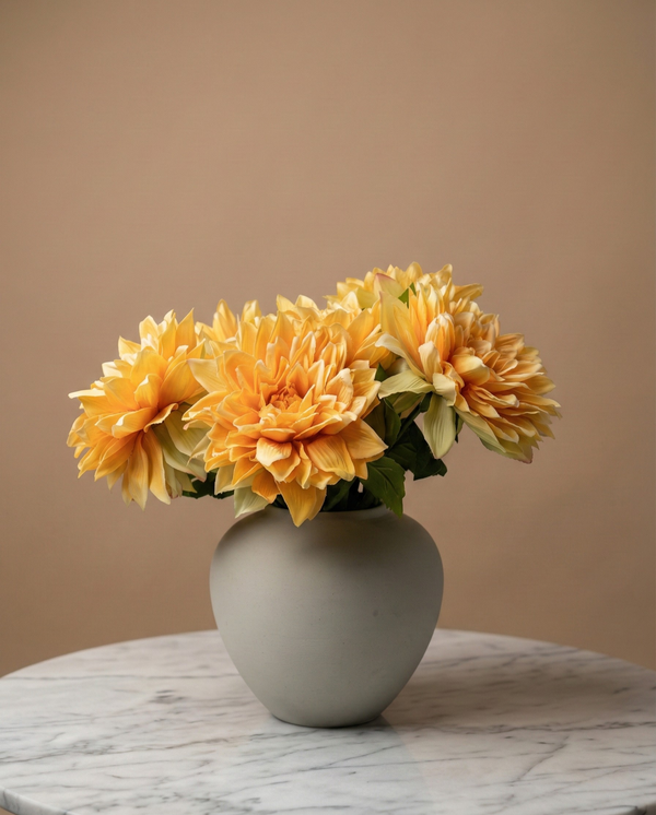 Real touch apricot orange faux dahlia arrangement in a matte ceramic vase on a round marble table #apricot-orange