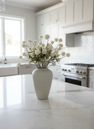 White real touch faux pompom flowers styled in a matte ceramic vase on a marble kitchen island #white