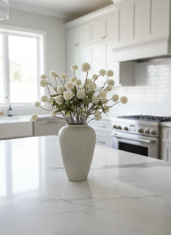 White real touch faux pompom flowers styled in a matte ceramic vase on a marble kitchen island #white