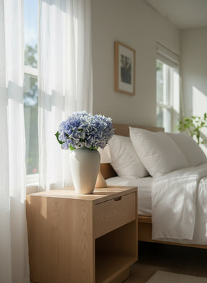 Lifelike blue faux hydrangea arrangement in white ceramic vase on bedside table #periwinkle-blue
